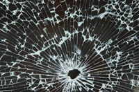 Bullet hole in window illustrating crime and violence